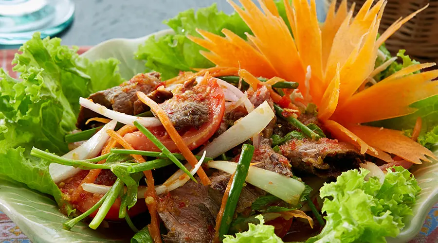 Plated Thai dish with carved vegetable garnish (no caption on their site)