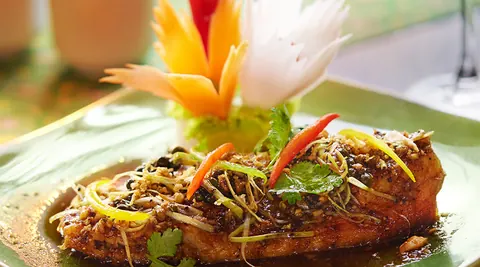 Plated Thai dish with carved vegetable garnish