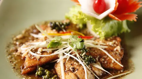 Plated Thai dish with carved vegetable garnish