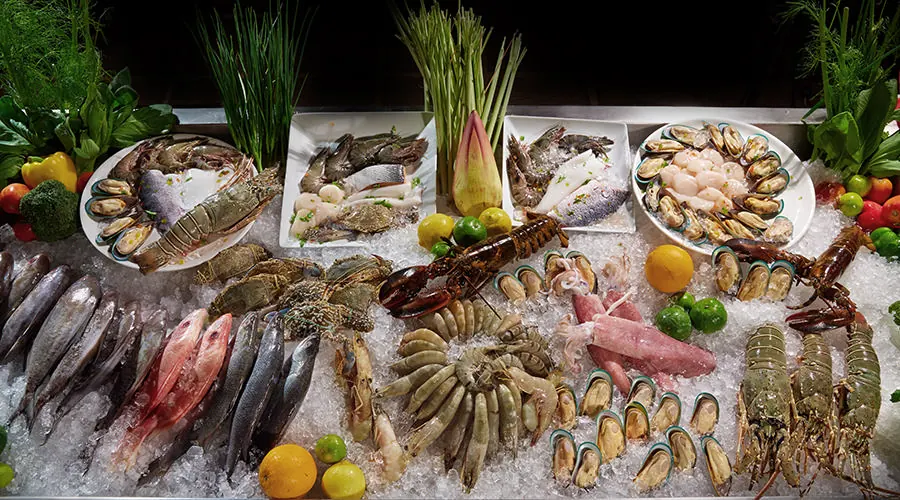 Fresh seafood on ice: fish, prawns, crab and shellfish, with herbs